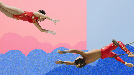 A vibrant image depicting two acrobats in mid-air, showcasing a dynamic aerial performance. One is dressed in a red costume with intricate designs, while the other is also in a matching outfit. They are reaching toward each other, set against a colorful background of soft pink and blue gradients with stylized clouds.